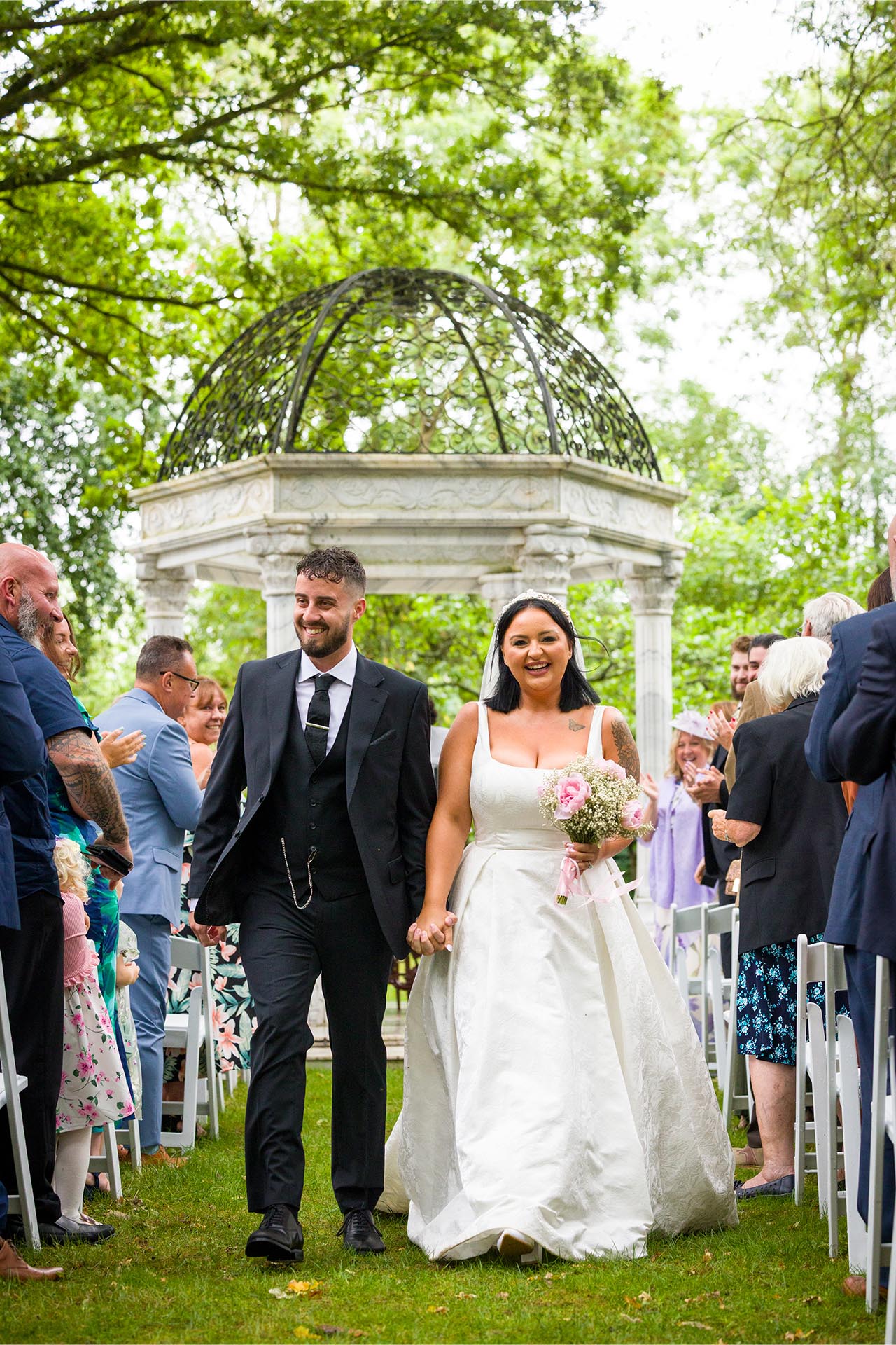 Photograph of bride and groom laughing during their wedding recessional at Creeksea Place Manor, Burnham-on-Crouch, Essex