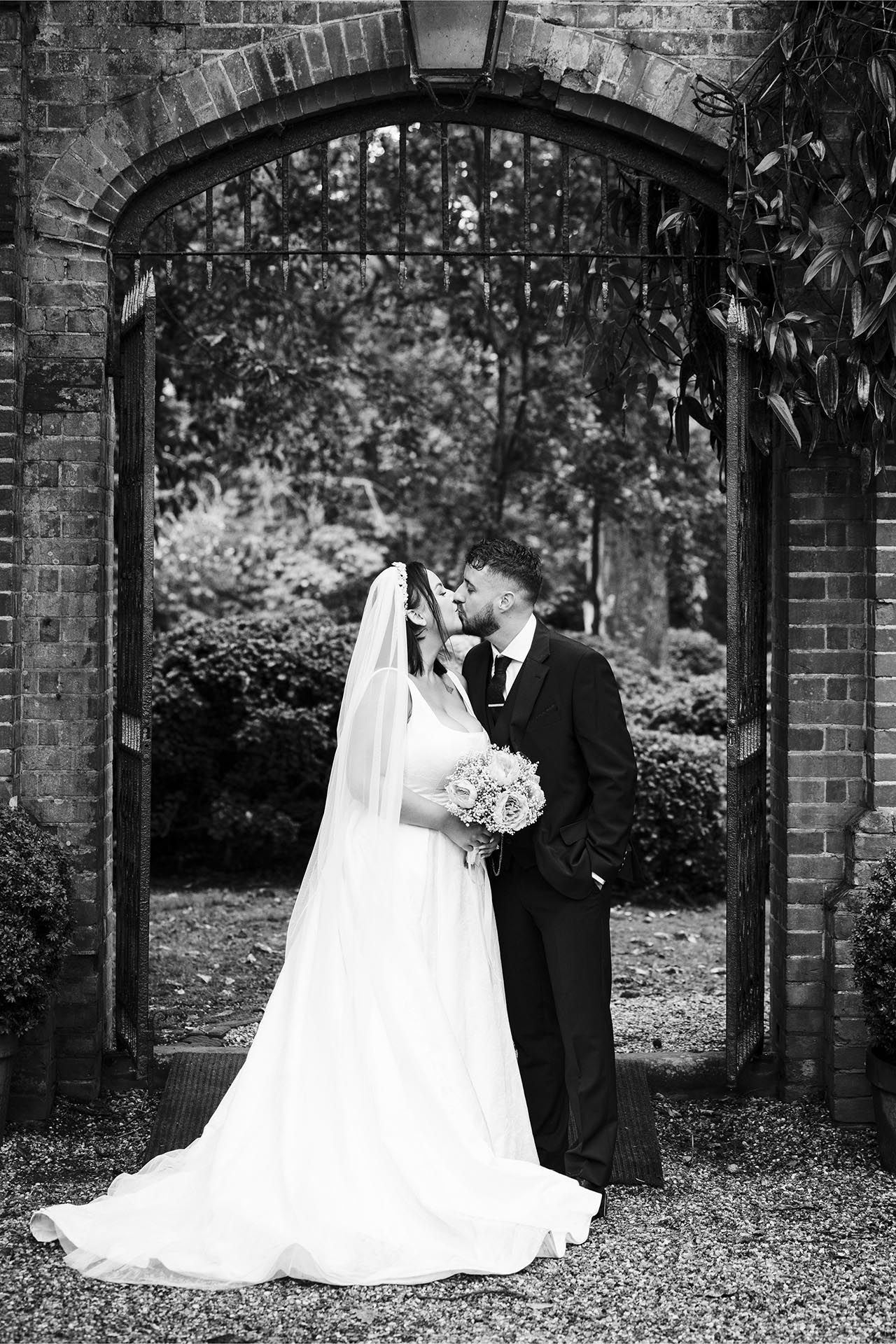 Black and white photograph of bride and groom kissing