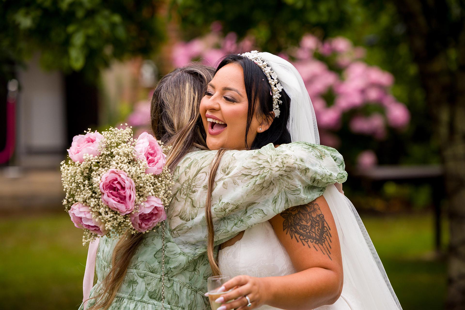 Photograph of bride hugging wedding guest