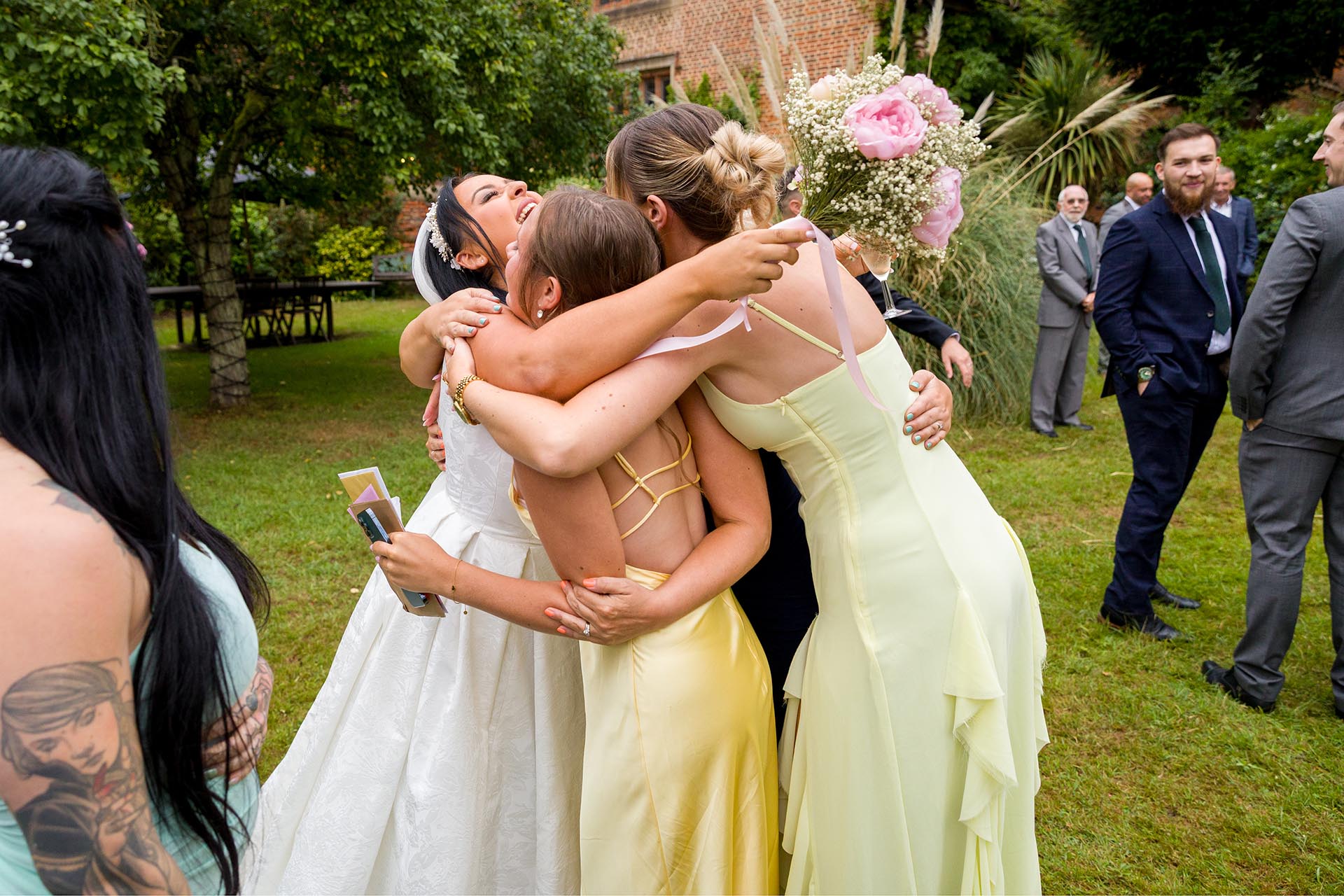 Photograph of bride hugging wedding guests