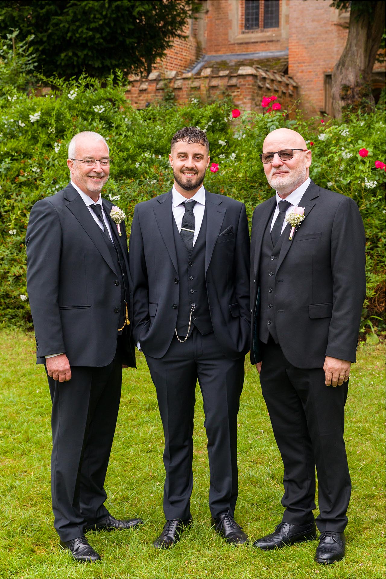 Wedding photograph of groom with father and father-in-law