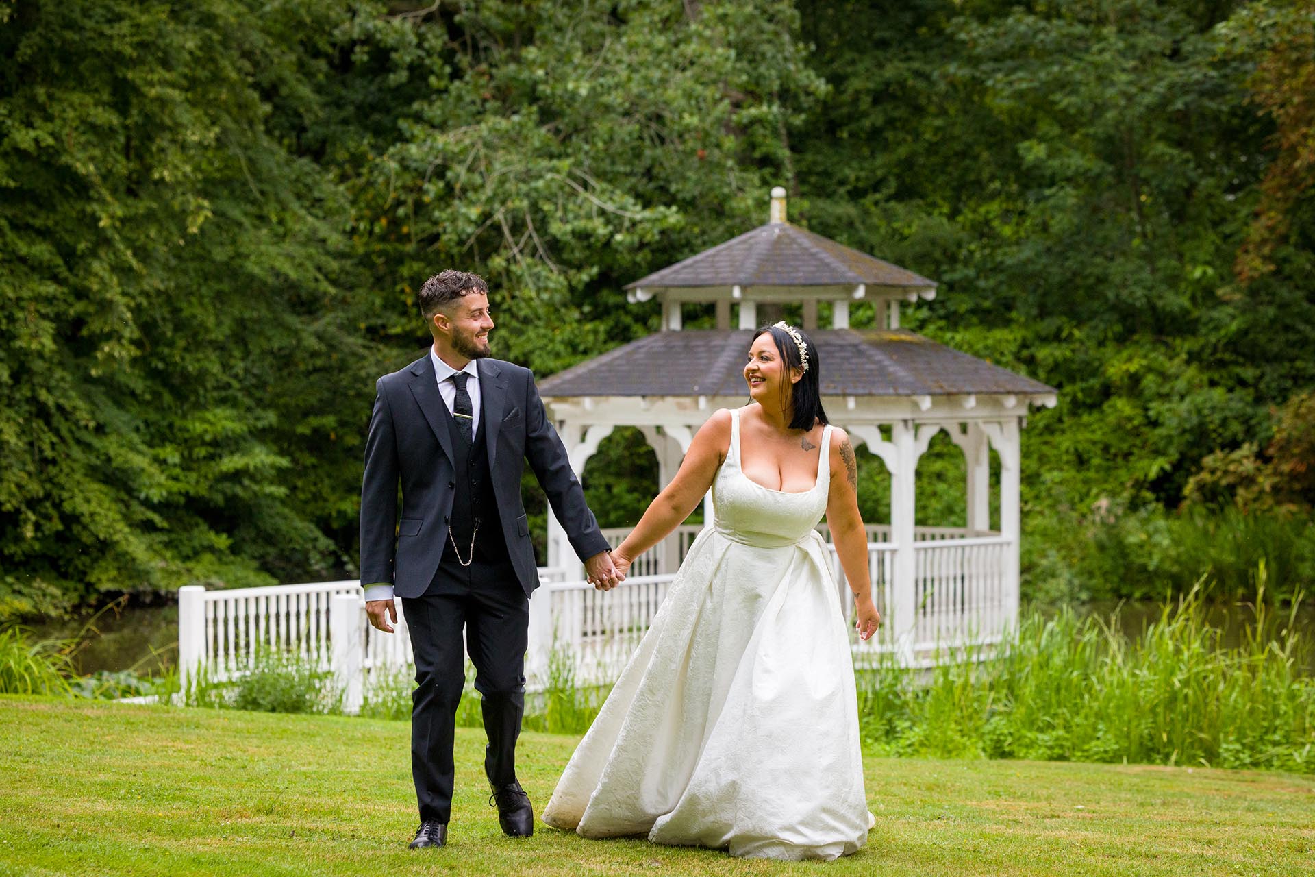 Photograph of bride and groom walking across the lawn at Creeksea Place Manor