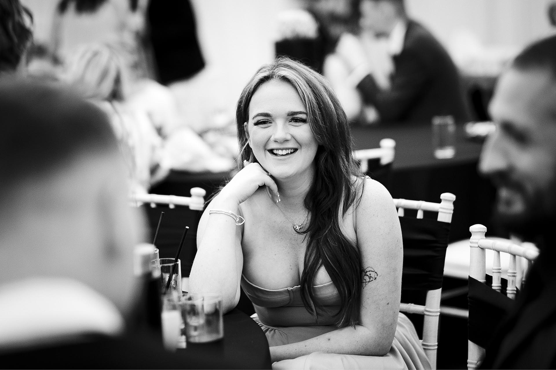 Black and white photograph of wedding guests laughing during reception