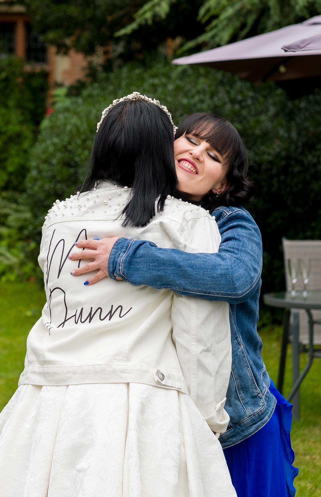 Photograph of a wedding guest hugging the bride
