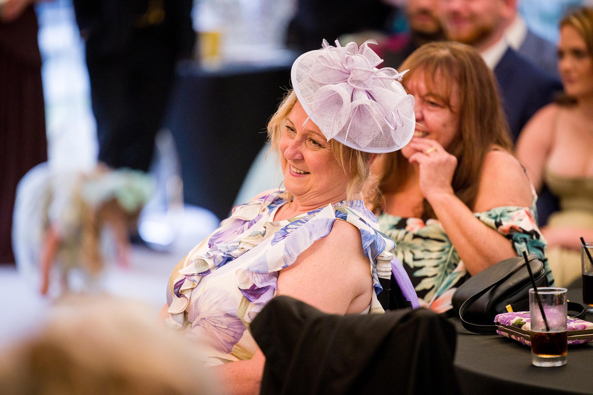 Photograph of wedding guests laughing during speeches