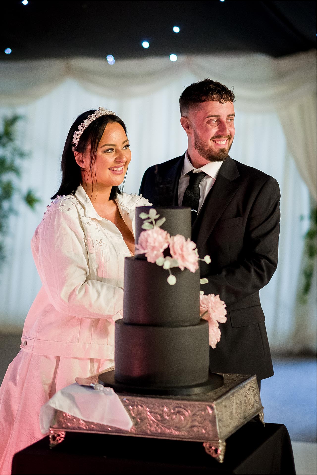 Photograph of bride and groom cutting their wedding cake