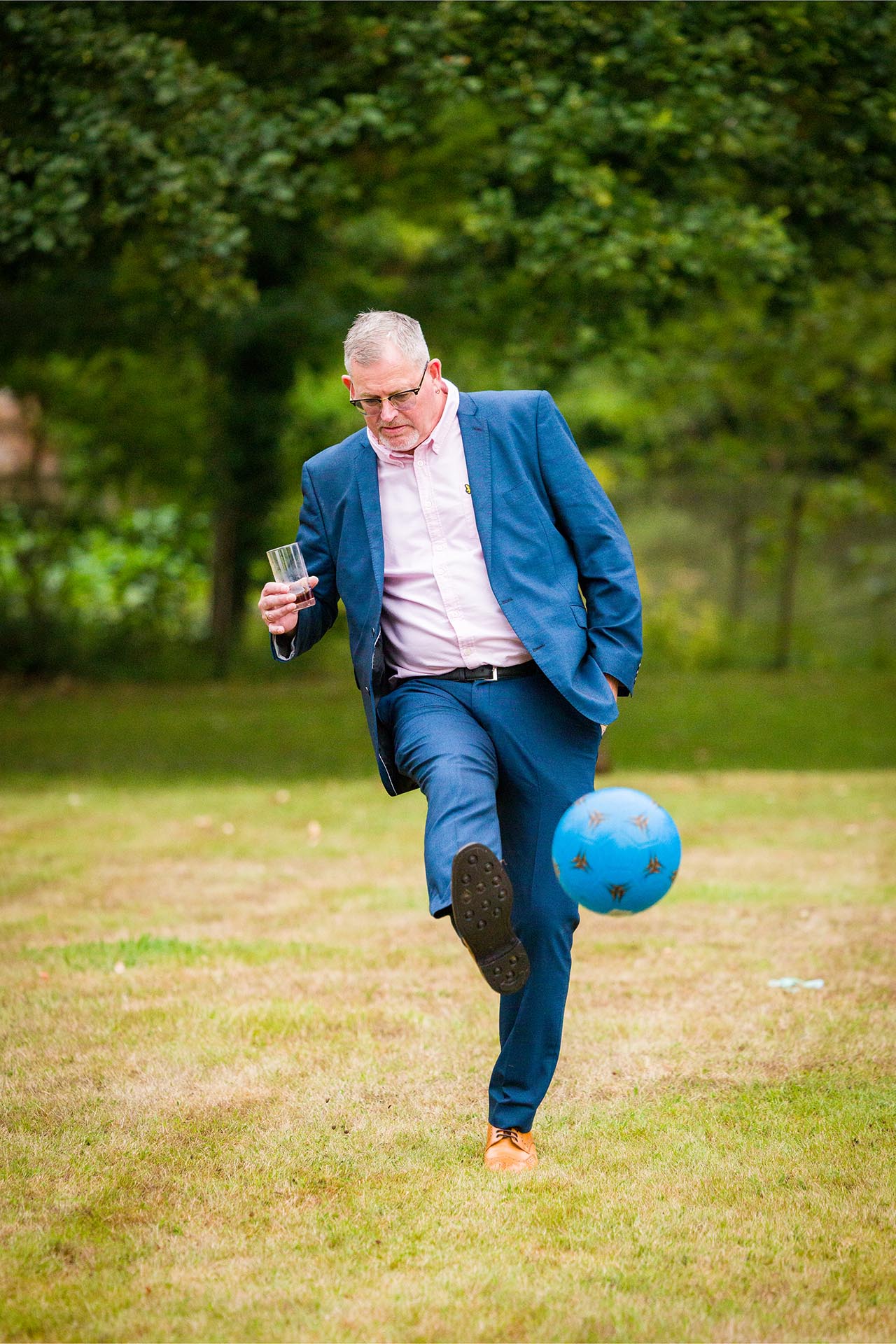 Photograph of wedding guest kicking a football