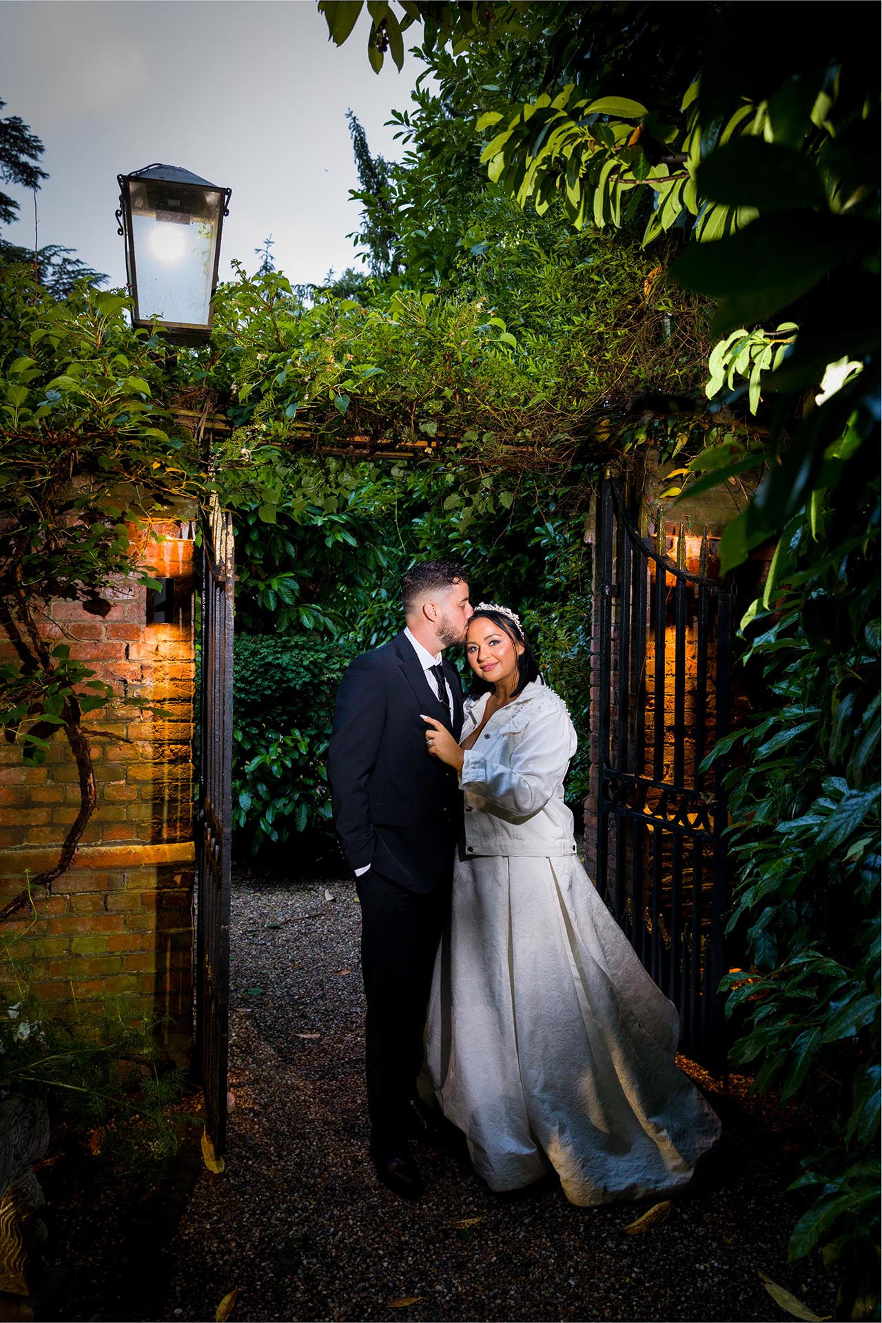 Twilight photograph of groom kissing bride at Creeksea Place, Burnham-on-Crouch, Essex