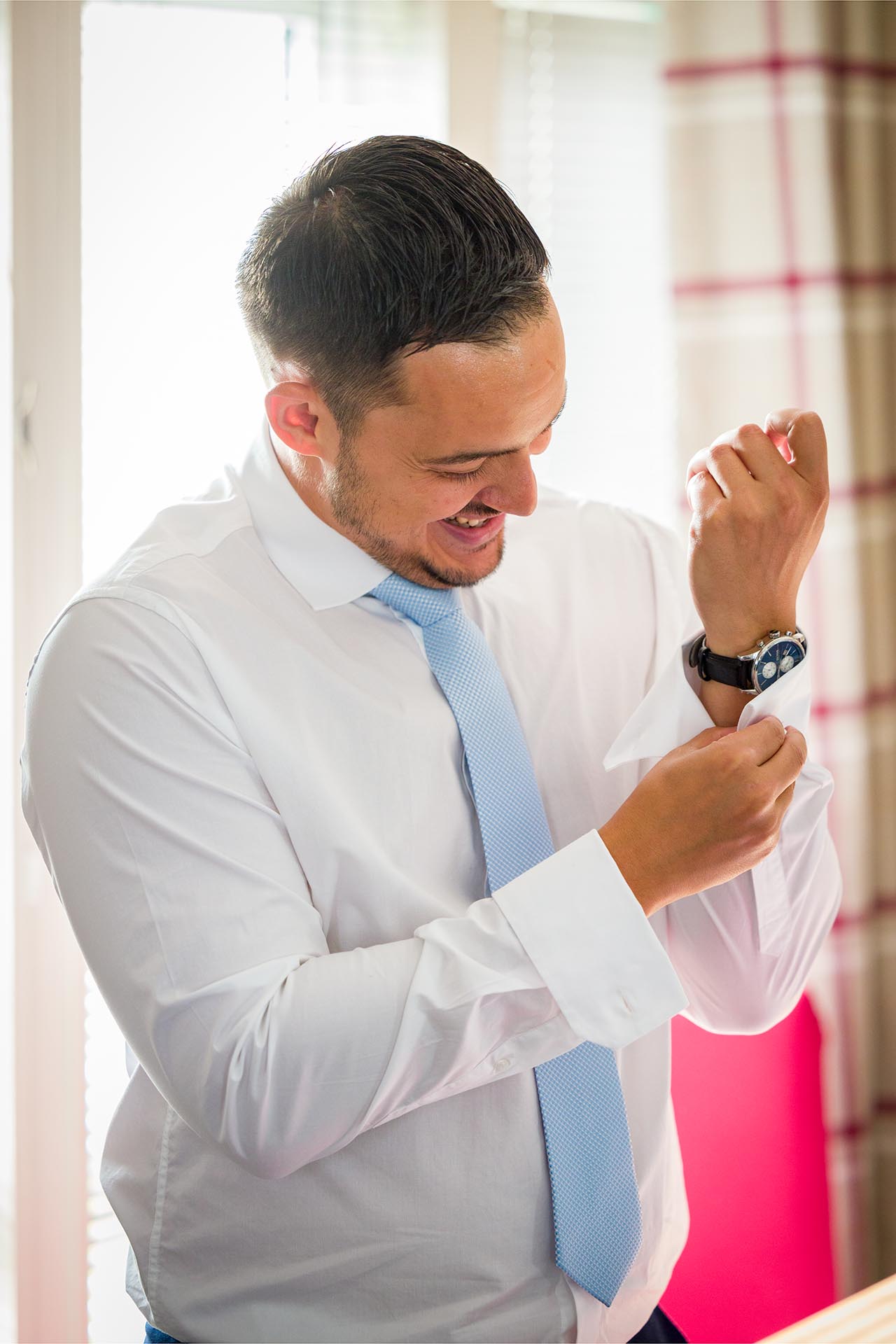 The groom fastening his cufflinks