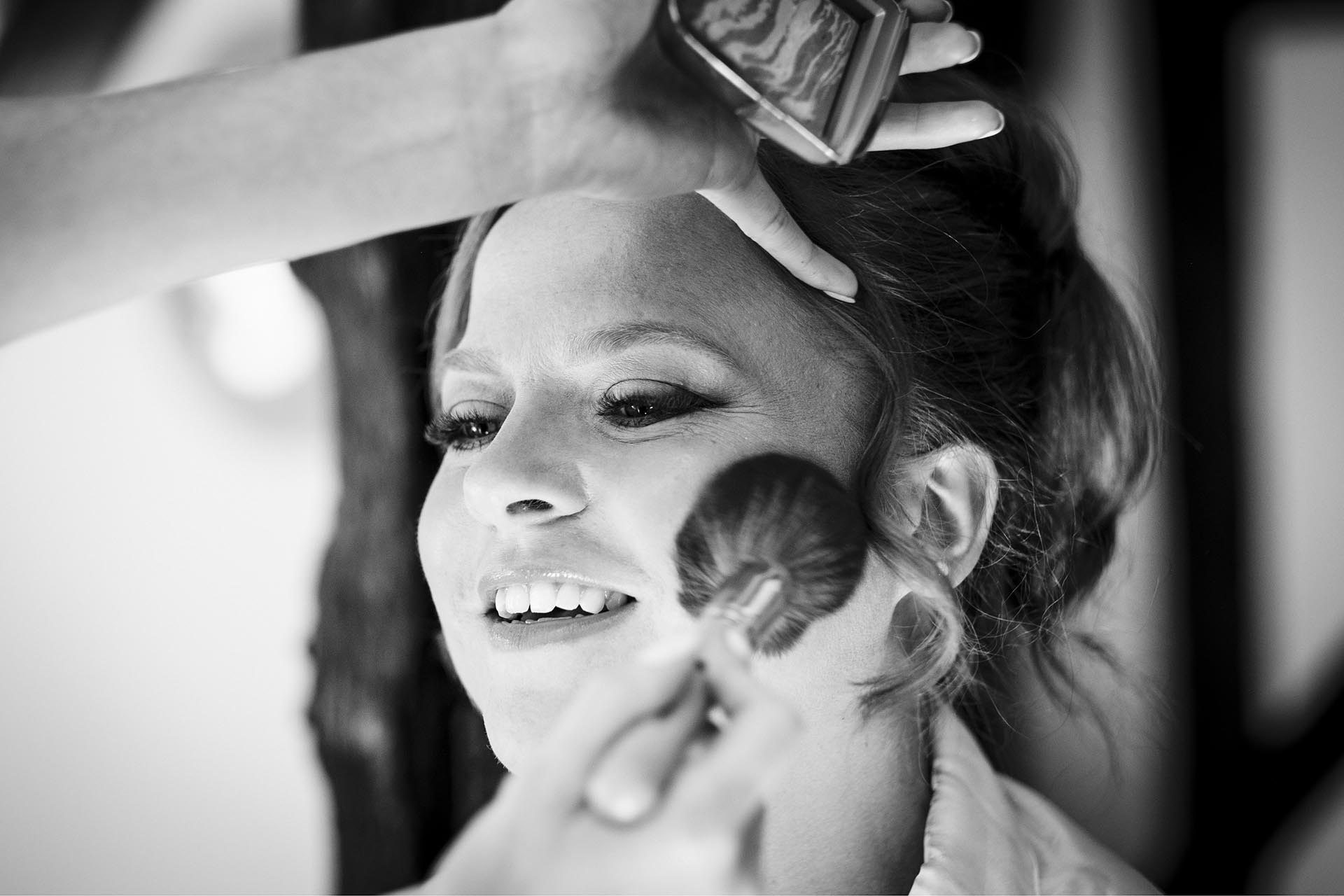 Black and white photograph of make-up being applied to bride