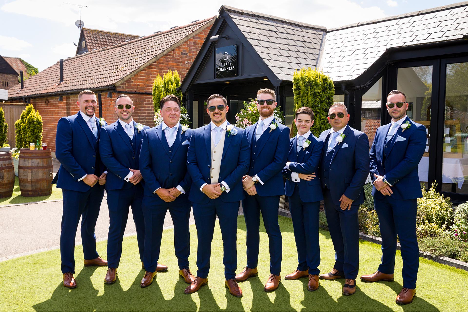 Groom and groomsmen group photograph outside Little Channels wedding venue