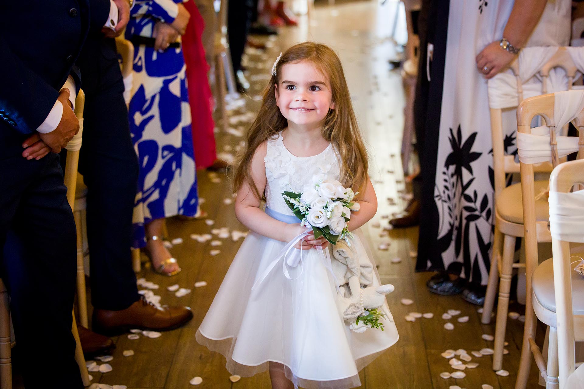 Young flower girl walking down the aisle