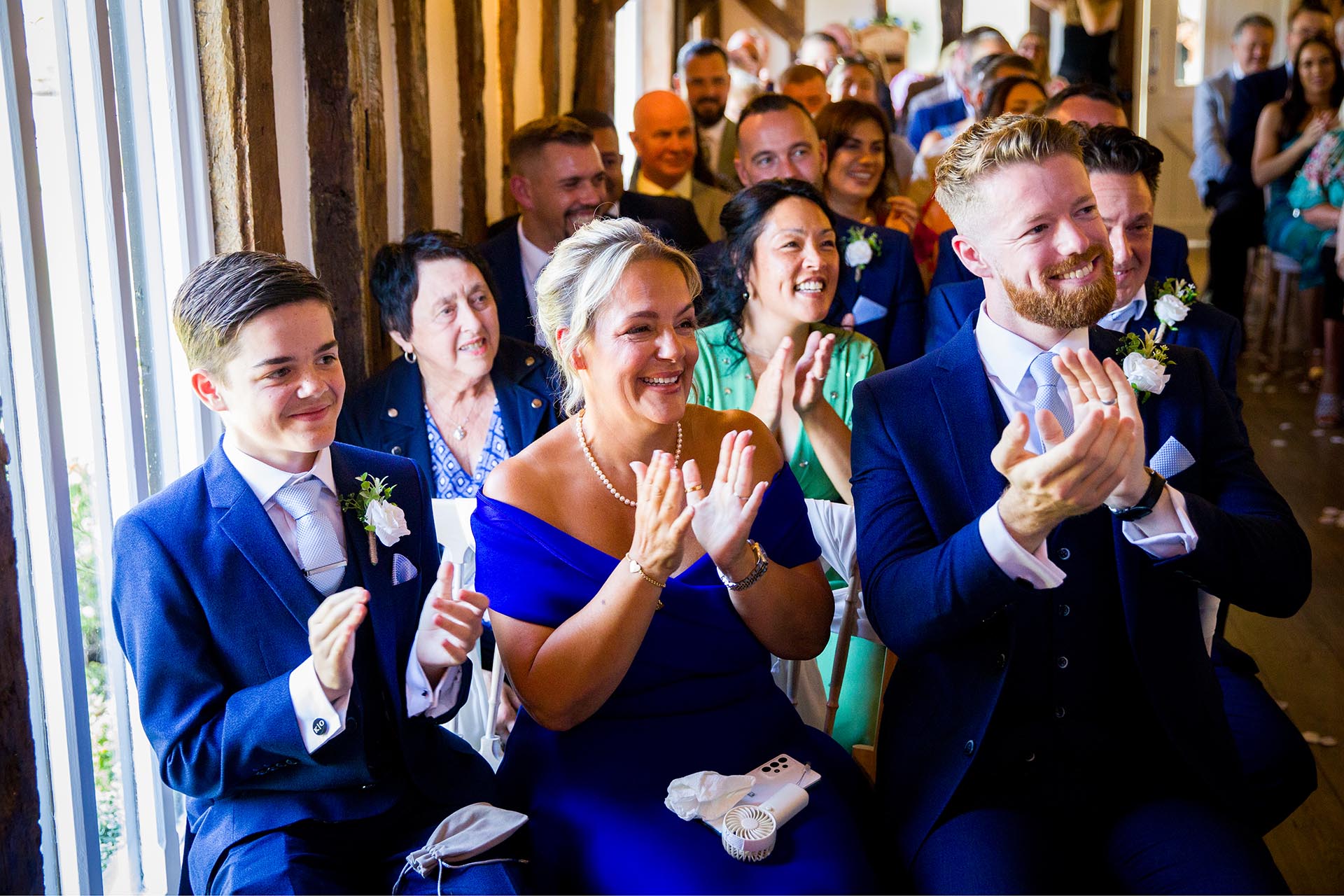 Smiling wedding guests clapping hands