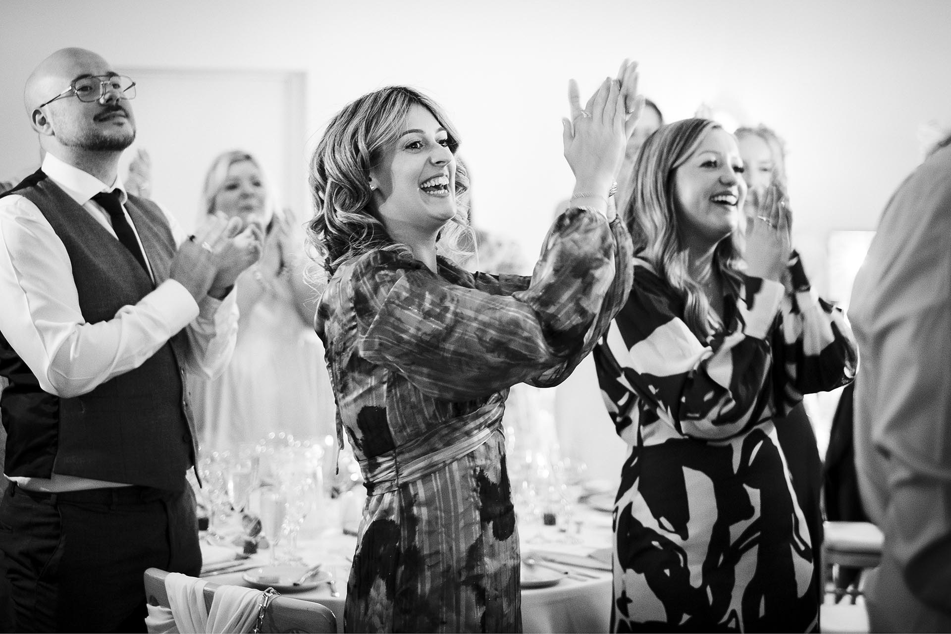 Black and white photograph of wedding guests applauding