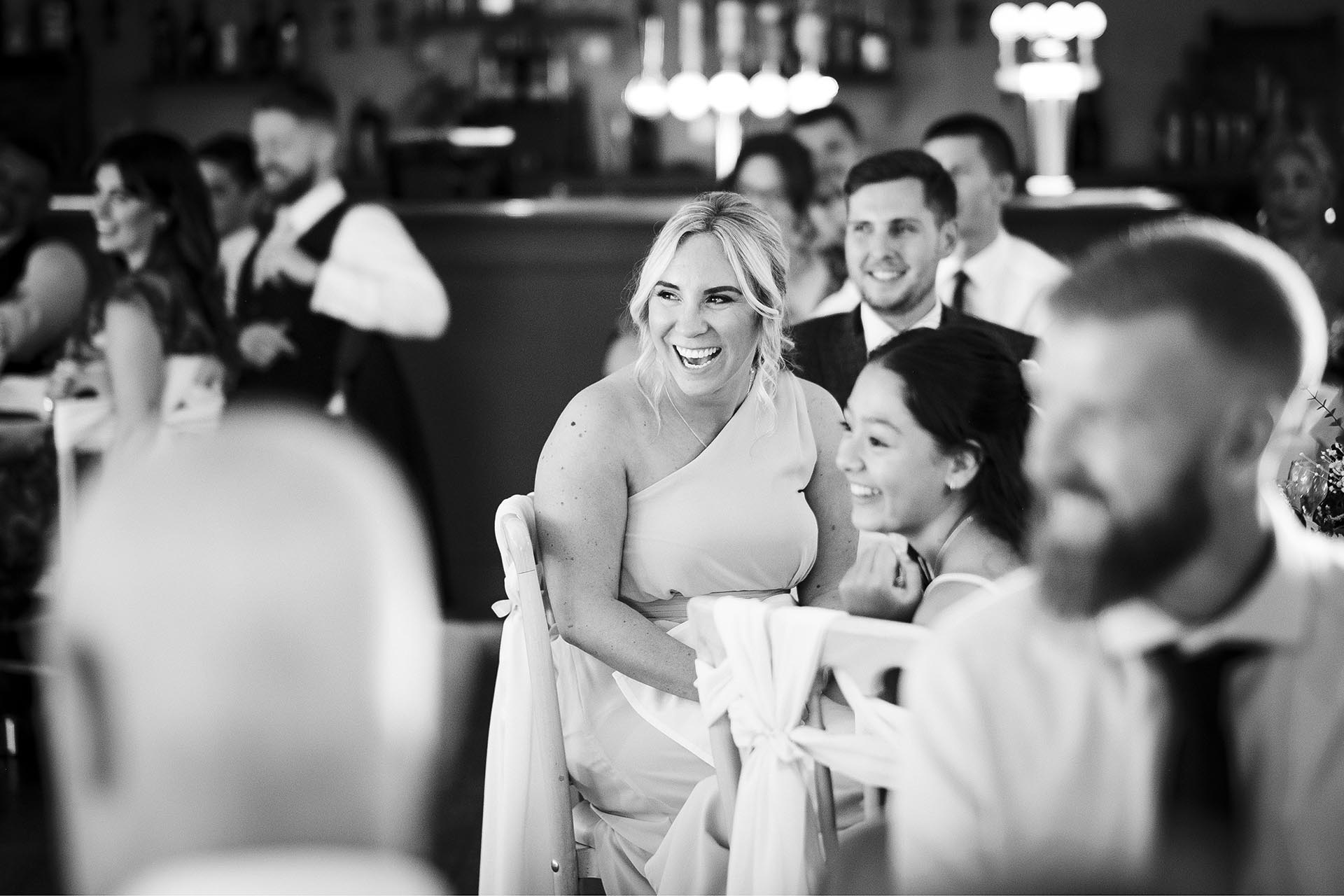 Black and white photograph of wedding guests laughing