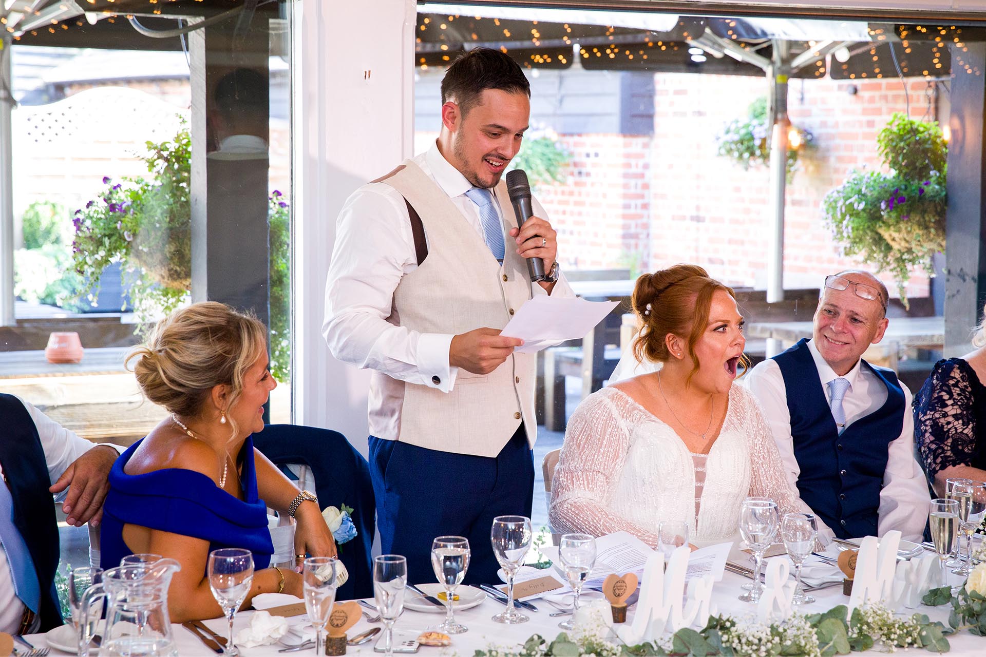 Groom giving his speech as bride has shocked expression