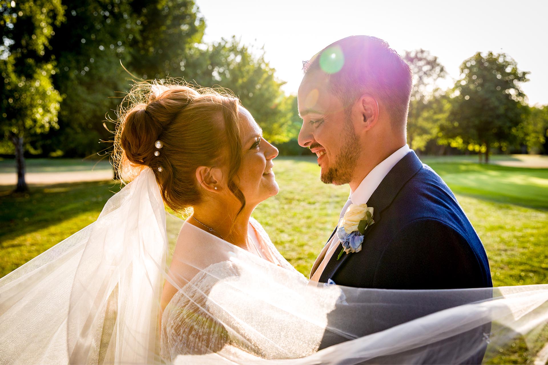 Bride and groom looking at each other in the late afternoon sun at Little Channels, Essex