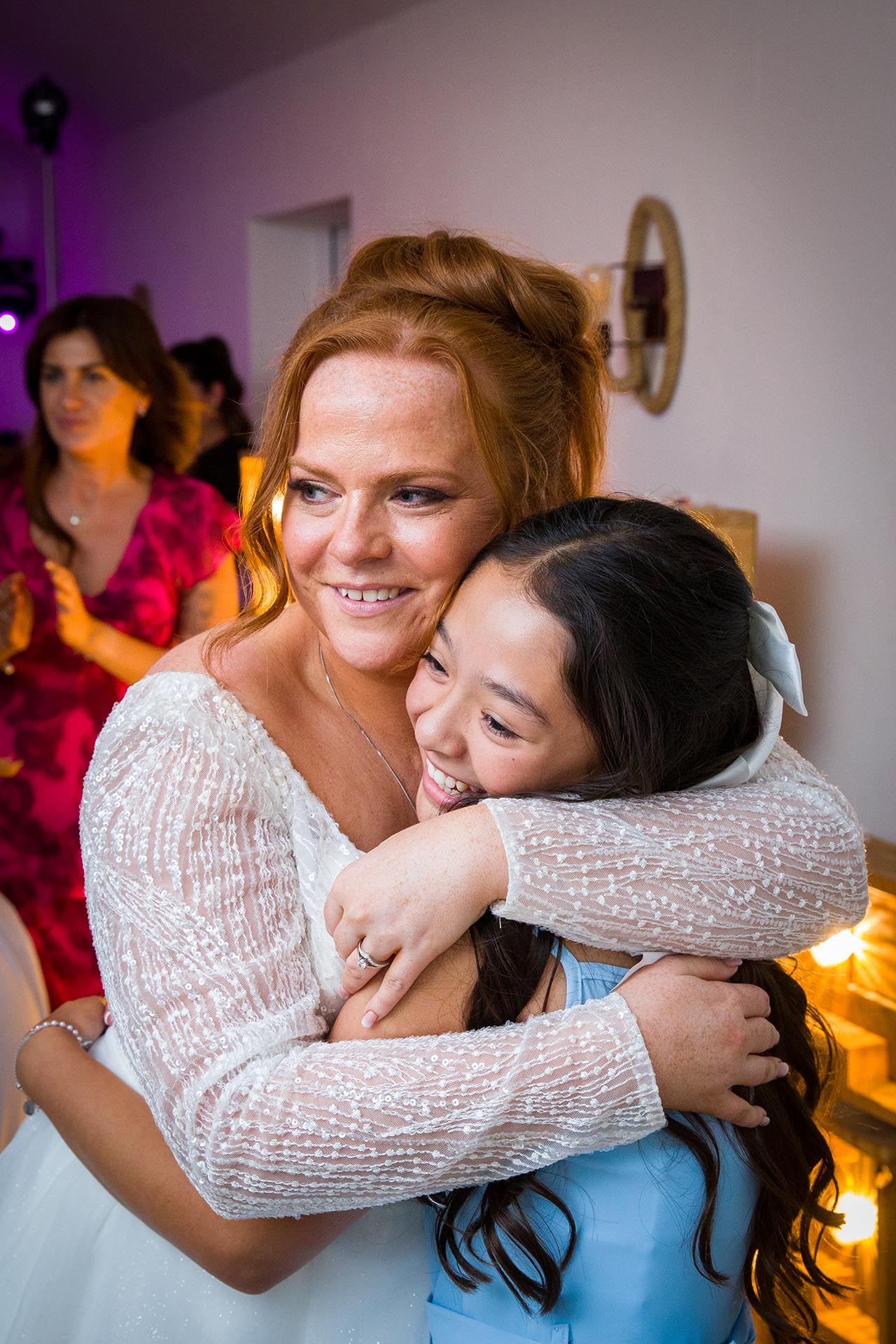 The bride gives a young wedding guest a hug