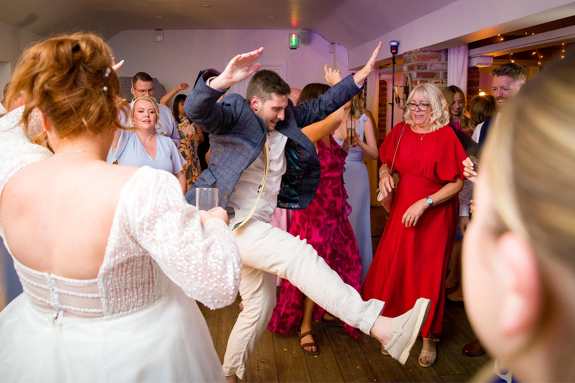 A wedding guest kicking his leg up on the dancefloor